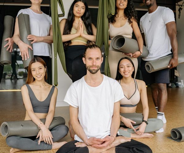 Diverse group of women smiling and preparing for a yoga class.